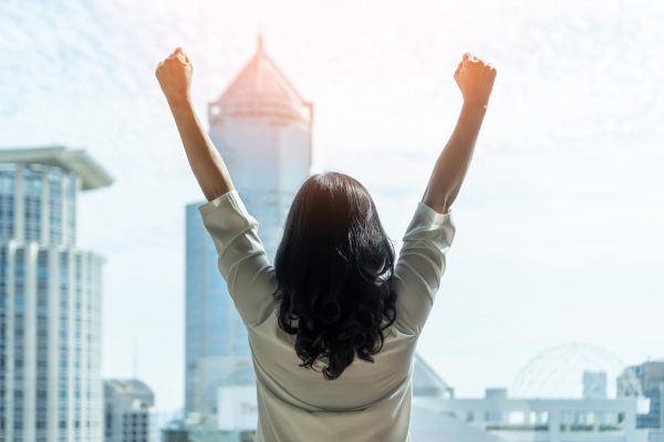Woman raising both arms above her head